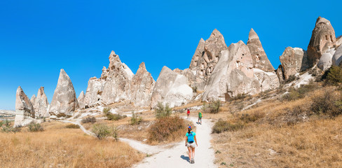Multiracial group of three friends tourist travel in fairy tale landscape of Cappadocia
