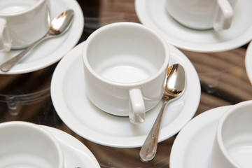 Close up dirty coffee cup and spoon setting on white saucer and wooden table after drinking in the morning in vintage style. cup