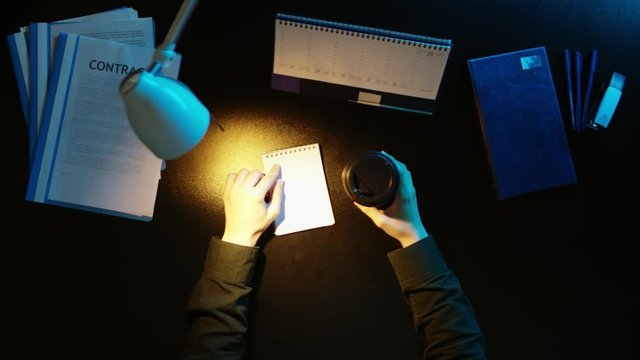 A man is sitting at an office desk and using a phone.
