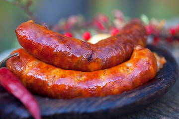 Homemade Hot Sausages. Grilled sausage on dark wooden plate