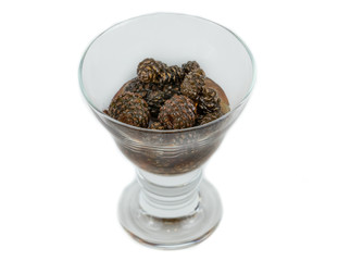 glass ramekin of jam made from pine cones on a white background