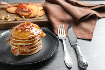 Tasty pancakes with bacon on plate