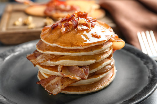 Tasty pancakes with bacon on plate