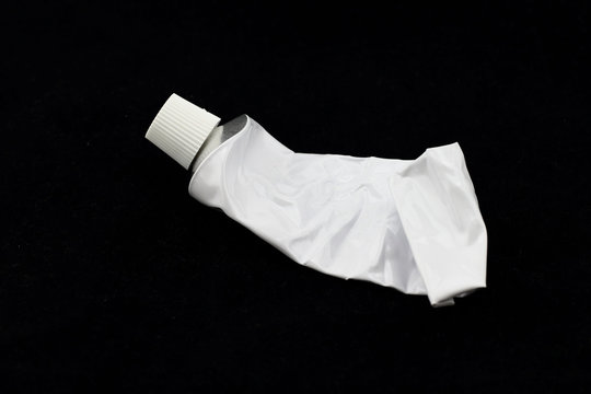 tubo gastado de aluminio esmaltado en blanco en fondo negro