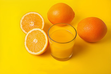 a glass of orange juice on a yellow background
