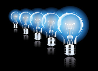 Hanging light bulbs with glowing one isolated on dark blue background