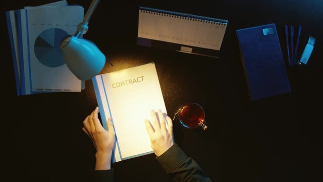 A man is sitting at an office desk and using a phone.