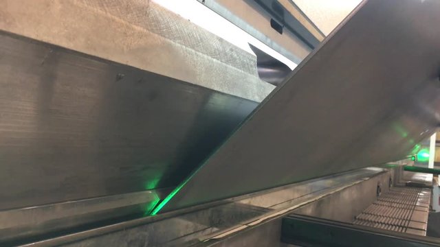 Big steel bending machine guided with green lasers takes in big steel sheet and bends to specifications.