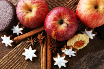 christmas cookies, apples, gingerbread and spice on brown background