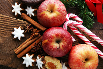 christmas cookies, apples, gingerbread and spice on brown background