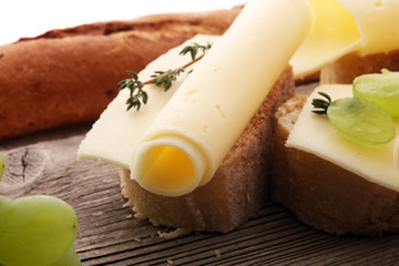 Cheese slices on bread or baghuette and grapes