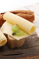 Cheese slices on bread or baghuette and grapes