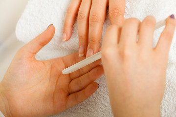 Woman getting manicure done file nails
