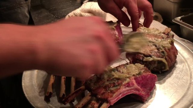 Lamb is prepared in high end restaurant kitchen by chef before being placed onto grill.