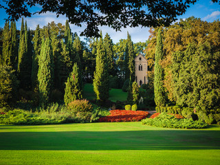 Small church in the trees and a immense green lawn.