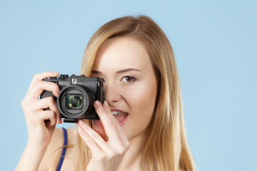 Blonde woman with camera on blue