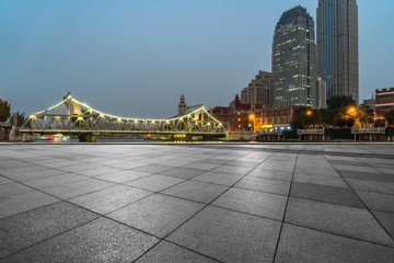 Fototapeta na wymiar night view of empty brick floor front of tianjin jiefang bridge