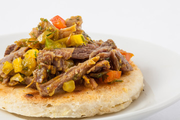 Traditional Colombian arepa topped with shredded beef