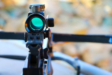 Crossbow optical sight  aiming from the first person on defocused blurred background