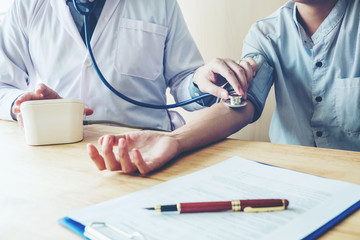 Doctor Measuring arterial blood pressure woman patient on arm Health care in hospital
