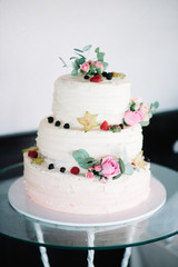Obraz na płótnie Canvas beautiful white wedding cake with flowers and fruits berries