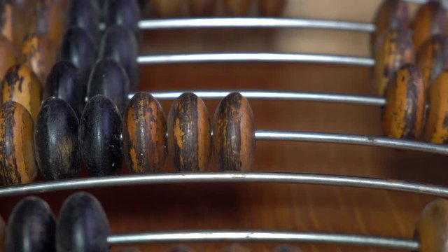 Old wooden abacus. A person does a mathematical or accounting calculation.