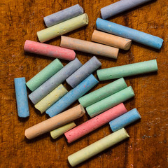 Colored chalk on wooden background.