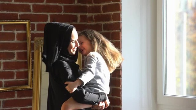 Arabic mother plays with small daughter.Slow motion.