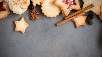 Ginger homemade cookies with strawberry jam on gray concrete background with Christmas tree. View with copy space. Flat lay, top view. Christmas Border - horizontal banner. Web size. stars.