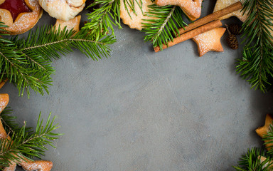 Ginger homemade cookies with strawberry jam on gray concrete background with Christmas tree. View with copy space. Flat lay, top view. Christmas Border - horizontal banner. Web size. stars.