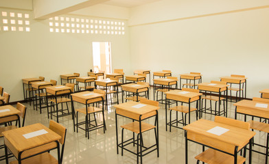 School empty classroom with test sheet or exams paper on desks chair wood and greenboard at high school thailand, education test concept