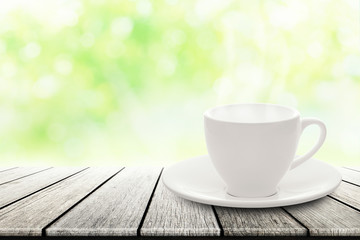 hot espresso with white ceramic coffee cup on wood table nature background blurred in garden.