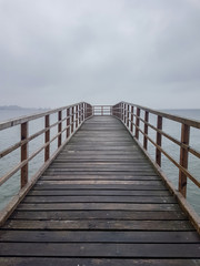 Fototapeta premium Seebrücke an der Strandpromenade von Eckernförde an der Ostsee Schleswig-Holstein an trübem Tag