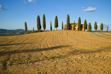 The harvested field and the old villa on a sunny September day. Tuscany, Italy