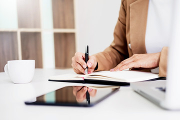 Hands of financial business women manager taking notes when working on report.
