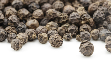 black peppercorns on white background