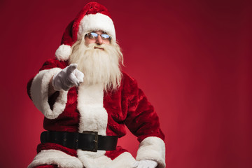 seated santa claus pointing his finger