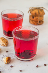 Red hibiscus tea in a glass cups and chocolate cookies