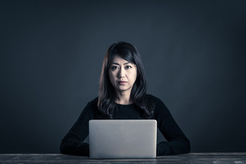 パソコンを操作する暗い雰囲気の女性