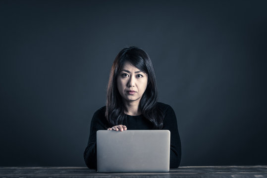 パソコンを操作する暗い雰囲気の女性