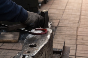 Making the horseshoe from heated red rod