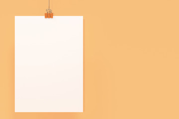 Blank white poster with binder clip mockup on orange background