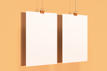 Two blank white posters with binder clip mockup on orange background