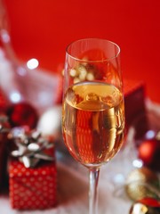 A glass of champagne with blurry Christmas decoration background.