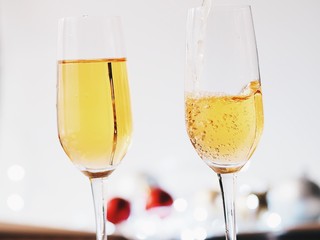 A glass of champagne with blurry Christmas decoration background.