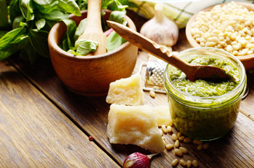 Pesto sauce ingredients and utensils on wood table