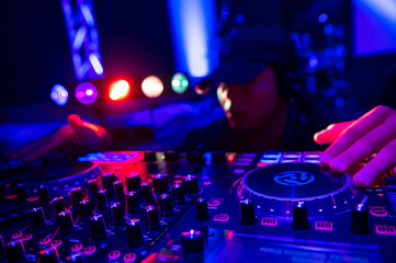 Fototapeta na wymiar Disc jockey at the turntable dj plays on the best famous cd players at nightclub