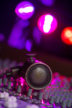 Vintage Microphone and Headphones on dirty sound mixer panel