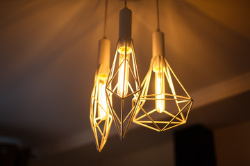 Fototapeta na wymiar Industrial pendant lamps against rough wall loft interior edison bulbs