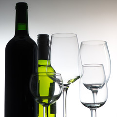 Set of wine bottles and glasses on grey background